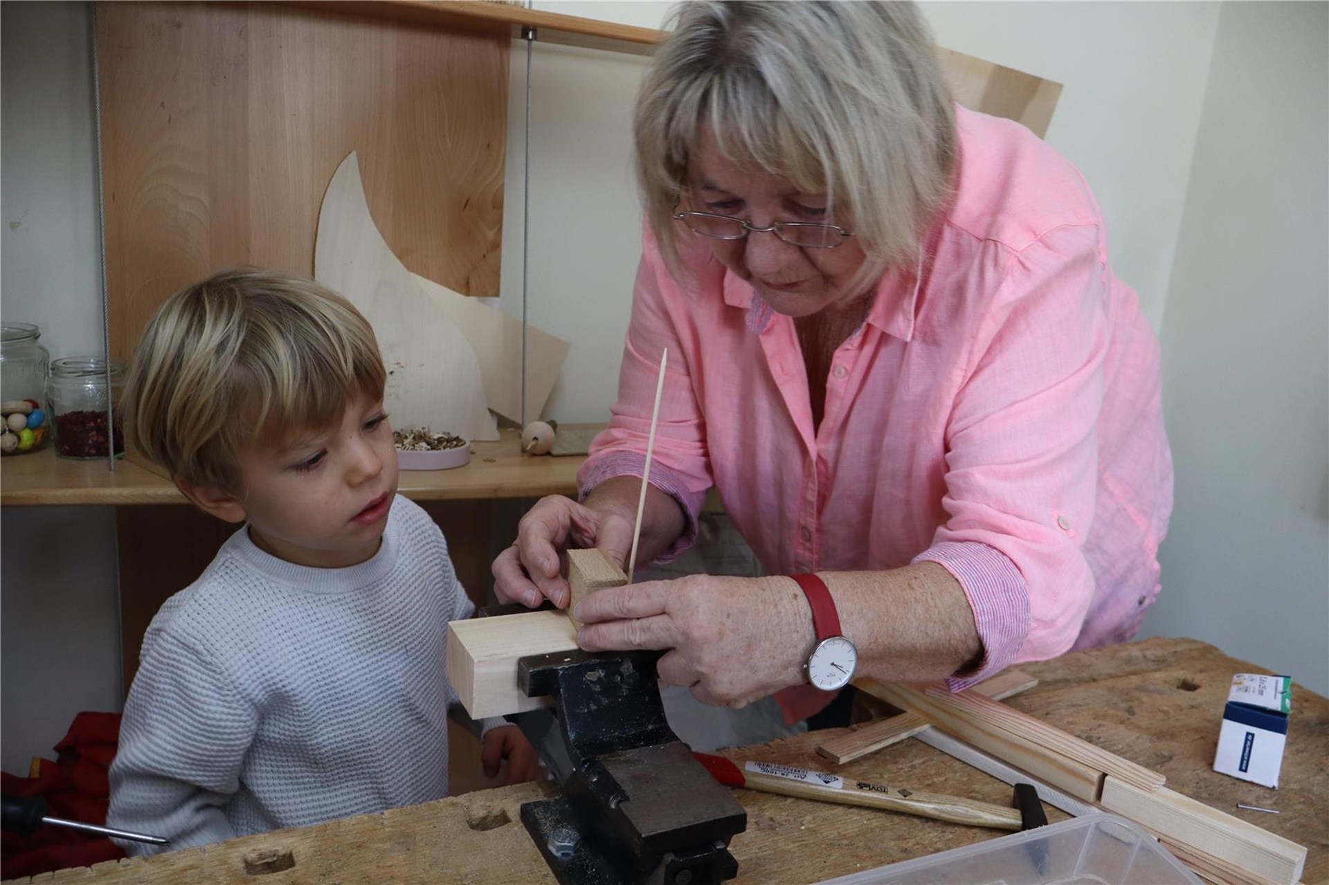 Eine Frau und ein Kind arbeiten an einem Stück Holz