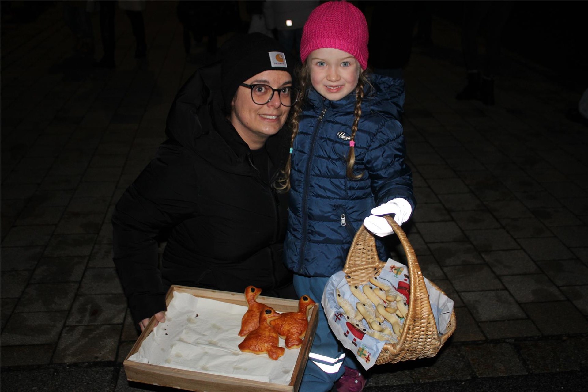 Eine Frau und ein Kind präsentiert eine St-Martins-Gebäck